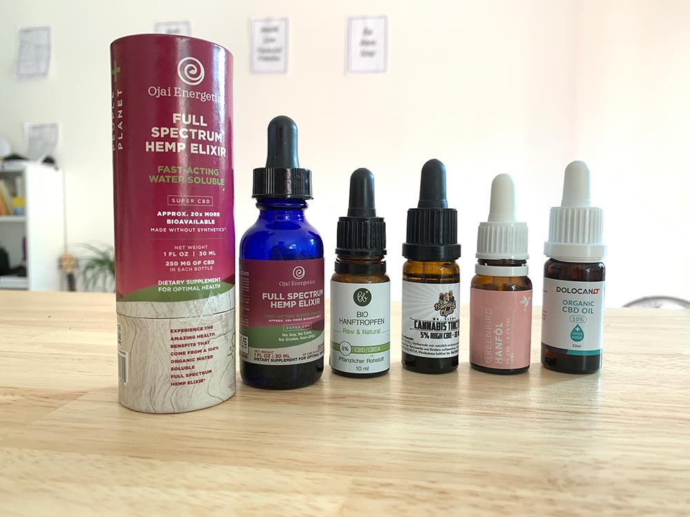 A bottle of Ojai Energetics' Full Spectrum Hemp Elixir next to four CBD oil bottles