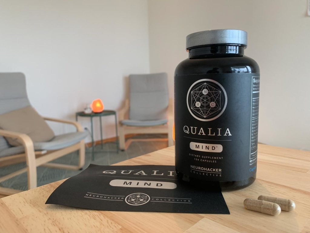 Eine Packung Neurohacker Qualia Mind steht auf einem Tisch mit 2 Kapseln