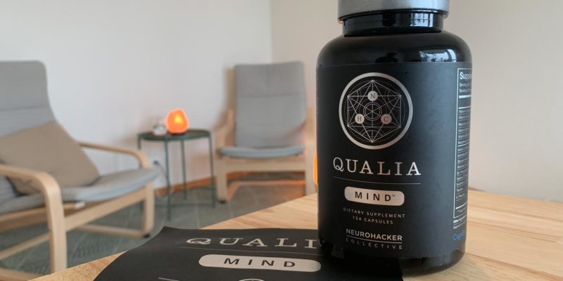 Eine Packung Neurohacker Qualia Mind steht auf einem Tisch mit 2 Kapseln