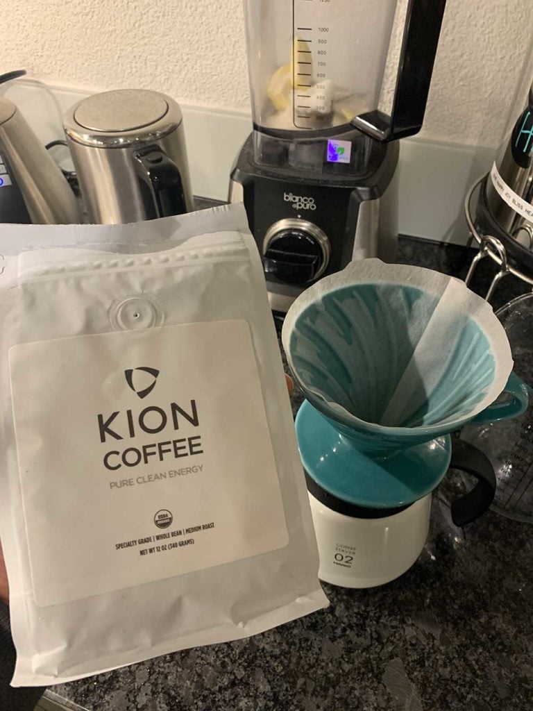 A bag of Kion Coffee infront of a Hario V60 coffee maker and a blender