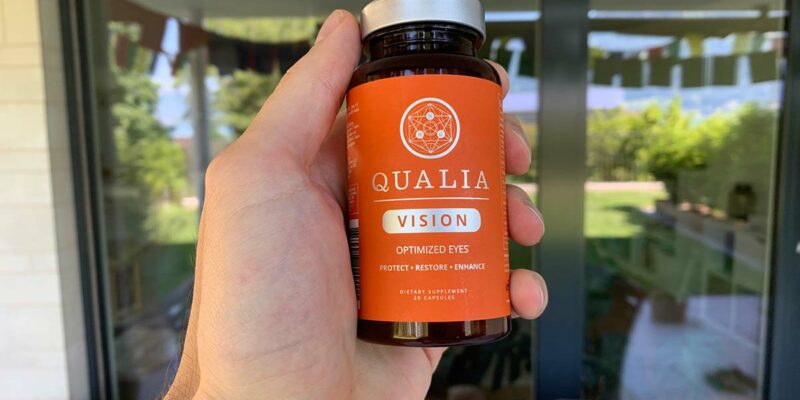 A hang holding a bottle of Qualia Vision