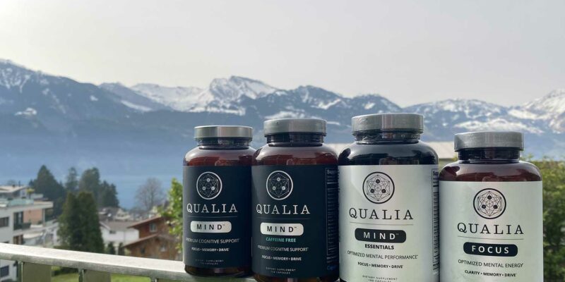 Bottles of Qualia Mind, Qualia Mind Caffeine Free, Qualia Mind Essentials, and Qualia Focus against a backdrop of Mountains