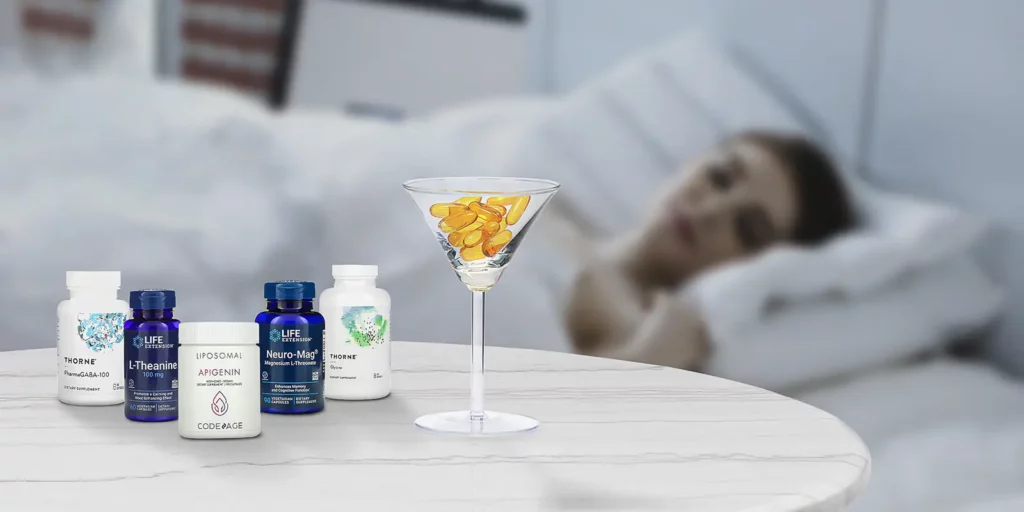 A Cocktail glass with supplement pills standing next to 5 supplement bottles. A person sleeping in a bed in the background.