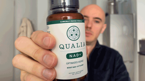 Max Hug showing the Qualia NAD+ bottle and taking two capsules as part of his review