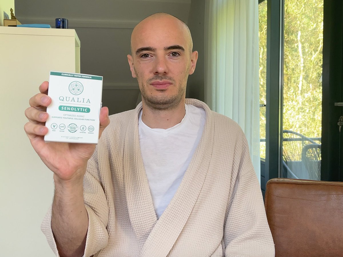 Max Hug holding a box of Qualia Senolytic supplement at home