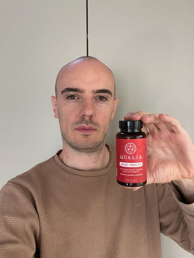 Supplement Expert Max Hug holding a bottle of Qualia Joint Health